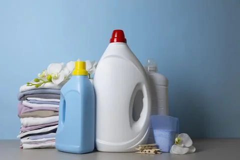 Laundry Detergents, stack of clothes and Washing Supplies on color Background Fotos Stock