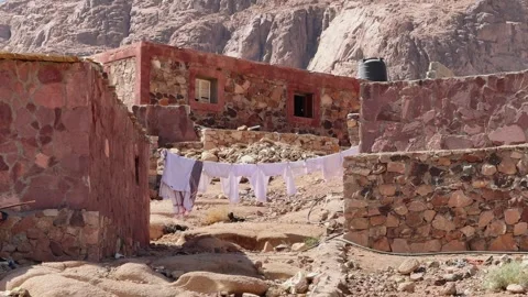 Laundry drying between inhabited stone houses in mountain village Video stock 341452128