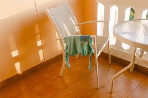 Laundry drying on a chair in a sunny balcony in a warm climate during the 스톡 사진
