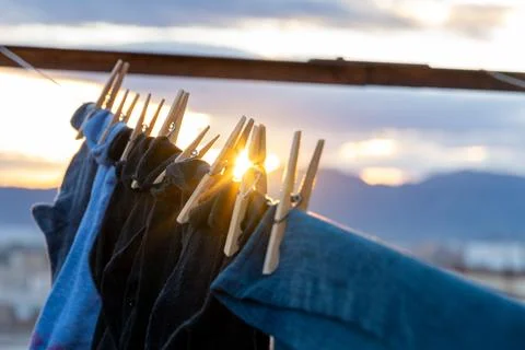 Laundry drying on clothesline during sunset golden hour Stock Photos