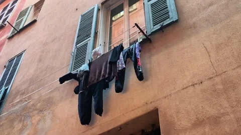 Laundry drying on clothesline outside old town window Video stock 336922710