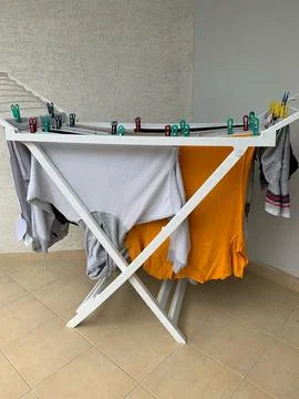 Laundry drying on drying rack indoors or outdoors, Fresh, clean clothes hanging  Stock Photos