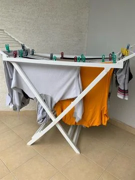 Laundry drying on drying rack indoors or outdoors, Fresh, clean clothes hanging Stock Photos