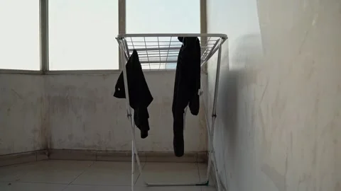 Laundry Drying On Metal Rack In Empty Room Stock Footage 337661623