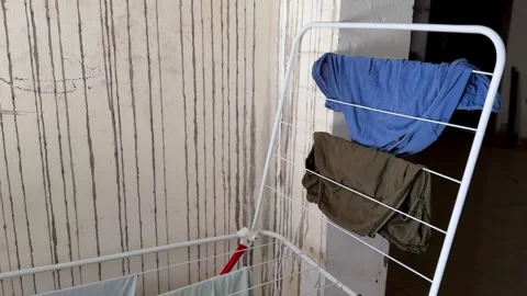 Laundry Drying On Rack Against Stained Wall Video stock 341396200