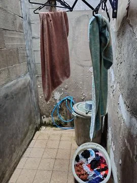 Laundry drying on a rack with a basket of clothes. Stock Photos