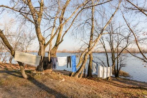 Laundry drying on a wire, under the mild winter sun, near the river Fotos Stock