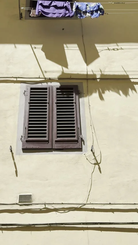 Laundry Hanging Above Traditional Window on Historic Italian Yellow Wall Stock Footage 340353616