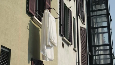 Laundry hanging on clotheslines to dry under the windows of a residential Stock Footage 314424674