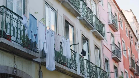Laundry hanging out to dry in narrow streets of city of Lisbon in Portugal Stock Footage 284529361