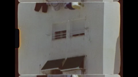 Laundry hanging outside apartment windows on Super 8 film Stock Footage 344440811