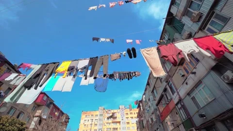 Laundry hung on clotheslines between apartment buildings. Video stock 176915664