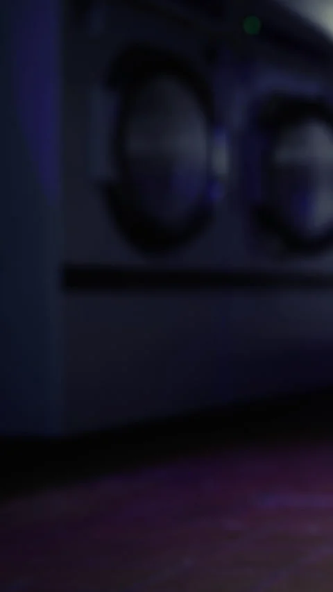 Laundry machines operating in a dimly lit laundromat at night Stock Footage 342449837