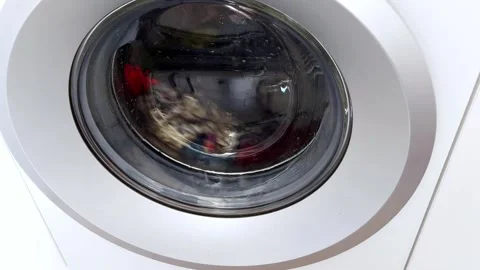 Laundry in Motion: Clothes Swirl Behind Glass in a Gentle Spin 스톡 동영상 315089336