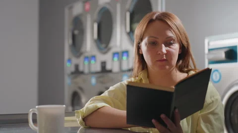 Laundry Owner Reading Notebook With Coffee Inside Laundromat Stock Footage 318856523