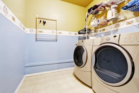 Laundry room interior in light blue and yellow colors Stock Photos