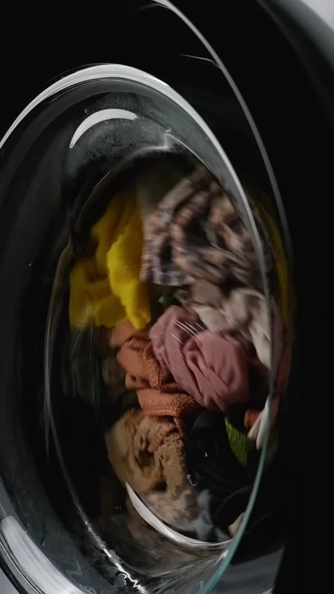 Laundry rotating in washing machine Stock Footage 304365307