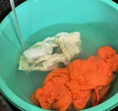 Laundry soaking in basin with water Stock Photos