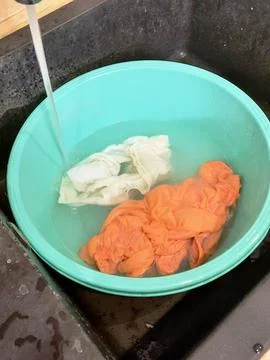 Laundry soaking in basin with water Stock Photos