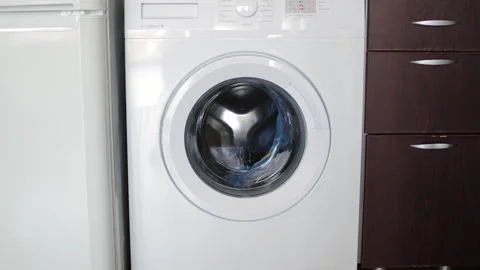 Laundry spinning inside modern washing machine drum, rotating wet clothes during Stock Footage 306948493