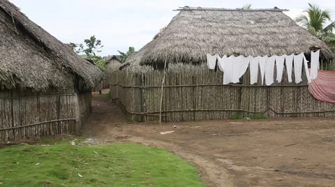 Laundry sways in wind next to grass huts 動画素材 42150738