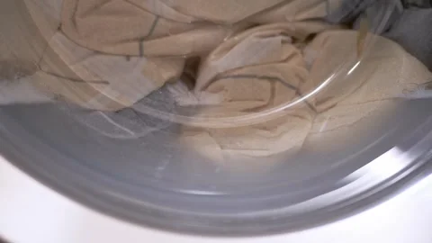 Laundry Tumbling Inside The Spinning Drum Of Front Loading Washing Machine 스톡 동영상 332663802