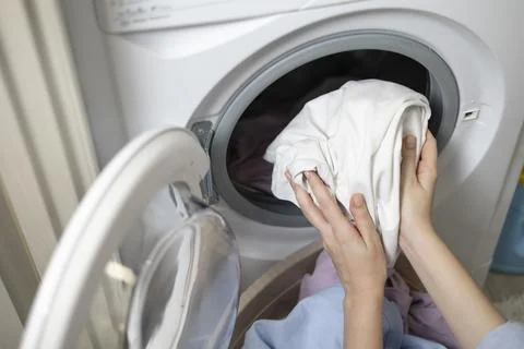 Laundry in washing machine, woman loading clothes, household cleaning and Foto stock