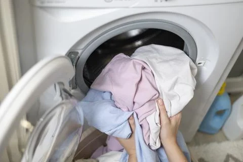 Laundry in washing machine, woman loading clothes, household cleaning and Stockfoto's
