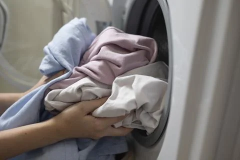 Laundry in washing machine, woman loading clothes, household cleaning and Stockfoto's