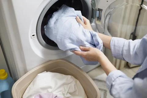 Laundry in washing machine, woman loading clothes, household cleaning and Foto stock