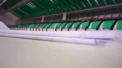 Laundry worker accepts ironed linen on the ironing line Stock Footage 171325540