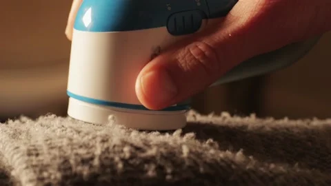 Laundry worker in the process of cleaning fur coat with lint remover spoons Stock Footage 238532665