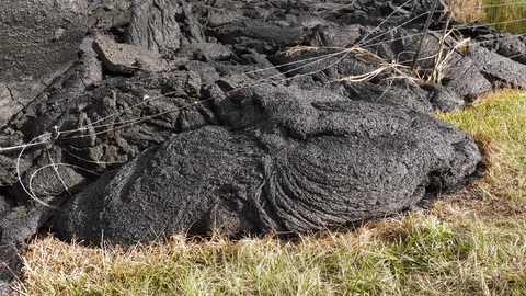 Lava creeps through bob wire fence Stock Footage 90463725