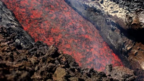 Lava flow in a detailed view flowing in the foreground on erupting Mount Etna Stock Footage 313005143