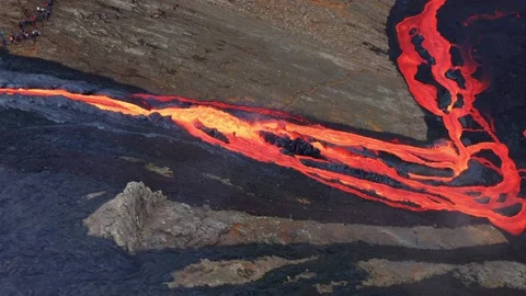 Lava Flow Emerges From Rock Column And Pours Into A Black Volcanic Stock Footage 162729395