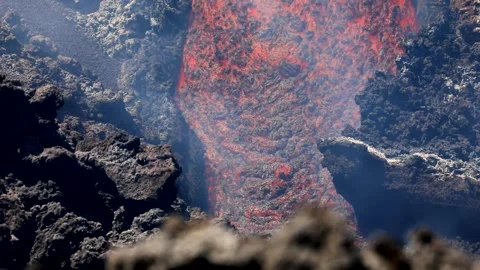 Lava flow flowing in the foreground on erupting Mount Etna - Sicily Stock Footage 312703321