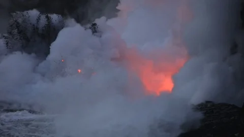 Lava flows into the ocean, after sunset, steam cloud rising from water surface Video stock 80679268