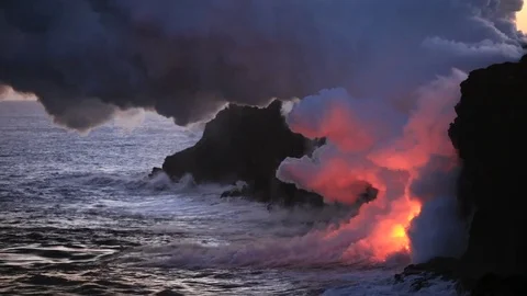 Lava flows into sunset ocean, steam cloud rising from water surface Video stock 80679390