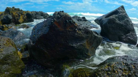 Lava rocks on beach with ocean waves. Calm waves slowly overlaying rocks 스톡 동영상 212498006