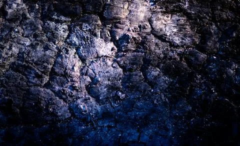 Lava texture background with dark volcanic surface. Lava macro closeup with r Stock Photos