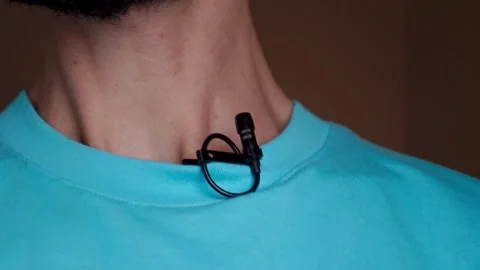 Lavalier microphone attached to the speaker's blue T-shirt Stock Footage 244516962