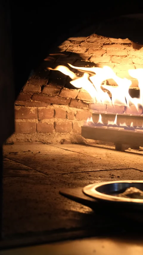 Lavash bread dough baking on a metal plate inside a traditional hot stone oven Video stock 345419372