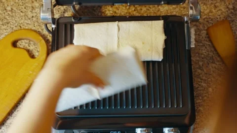 A lavash dish with stuffing is placed on an electric grill for further cooking Stock Footage 240625140