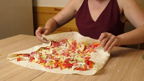 Lavash with vegetables wrapped in it. Preparing a dish from lavash. Stock Footage 316038496
