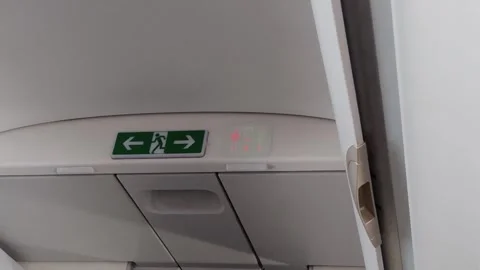 Lavatory Sign Changes in Airplane Cabin with Exit Sign During Flight Stock Footage 311545692