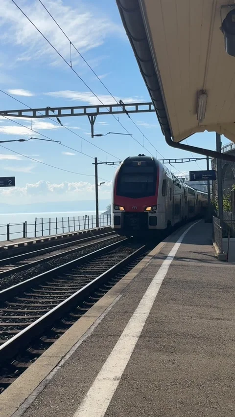 Lavaux train station platform with passing Swiss train Lake Geneva Stockbeeldmateriaal 332999066