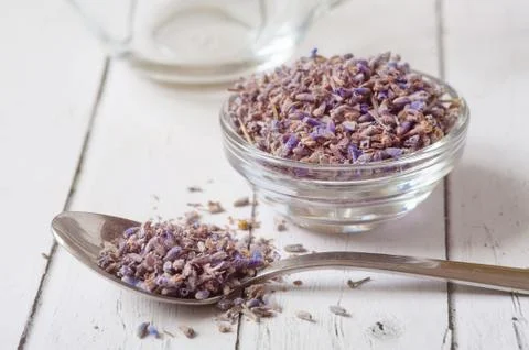 Lavender essential oil ingredients. Wooden spoon full of dry lavender seeds and Stock Photos