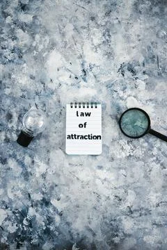 Law of attraction notepad with light bulb and magnifying glass symbol of intr Stock Photos