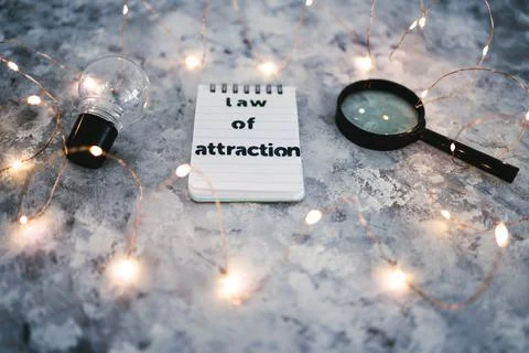 Law of attraction notepad with light bulb and magnifying glass symbol of intr Stock Photos