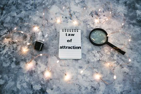 Law of attraction notepad with light bulb and magnifying glass symbol of intr Stock Photos